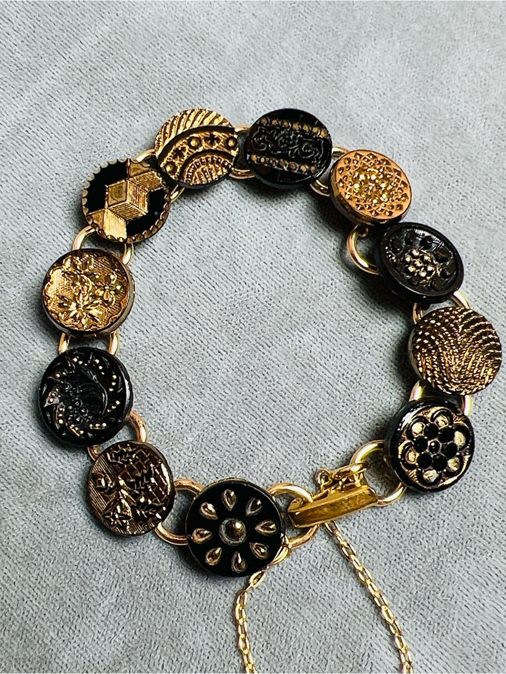 Antique button bracelet, gold luster black glass, fold over clasp, safety chain